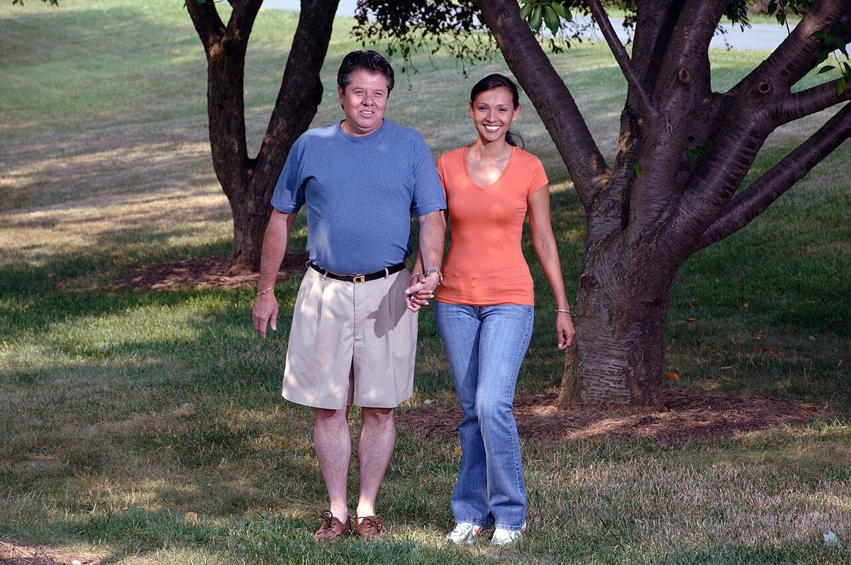 A smiling couple walking together in a sunny park